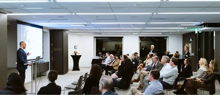 Image of presentation underway with a group of professional advisors listening to a speaker