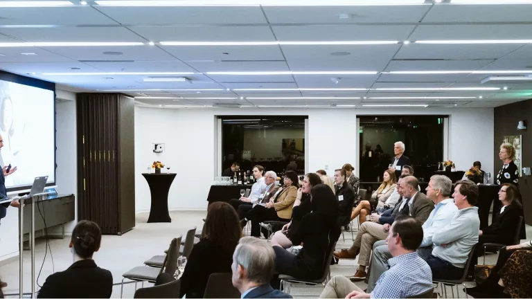 Image of presentation underway with a group of professional advisors listening to a speaker