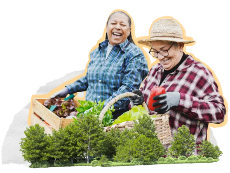 Two women in the garden laughing and smiling carrying baskets of produce