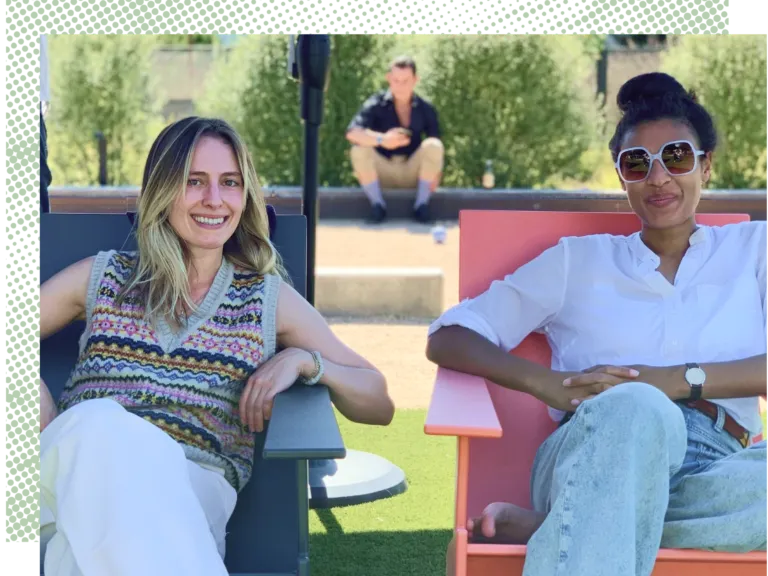 Two women lounge in lawn chairs, smiling and posing for a photo