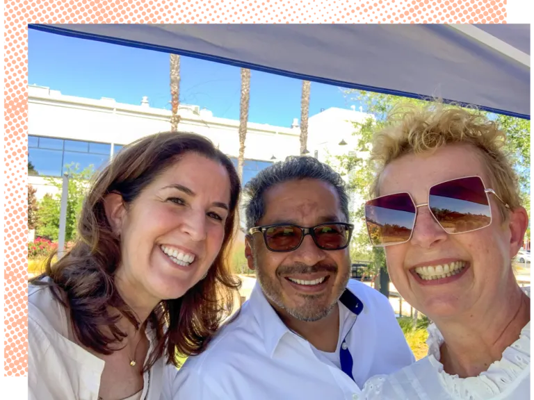 Three smiling MCF employees take a selfie together against a bright sunny background