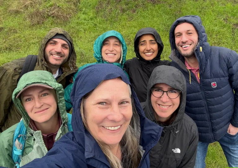 Seven MCF staff members dressed in rain gear during a hike in Marin