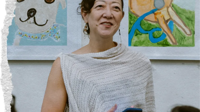 Rhea Suh stands addresses a crowd of people at an MCF all-staff meeting