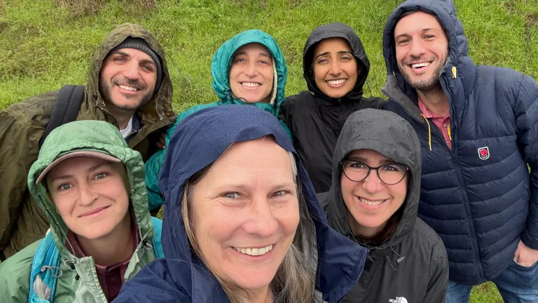 Seven MCF staff members dressed in rain gear during a hike in Marin