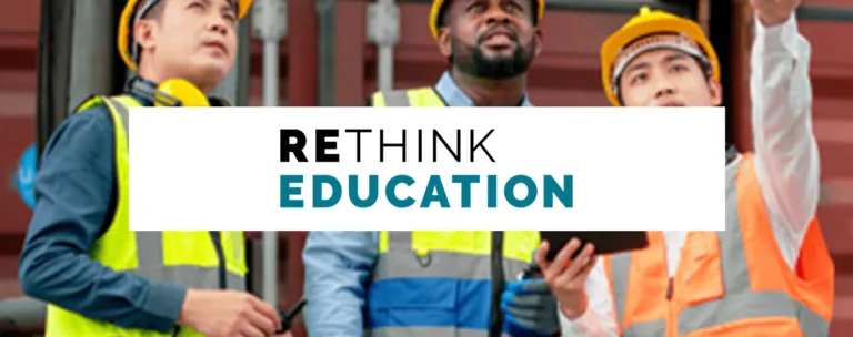 A man and two boys wearing hard hats and reflective vests