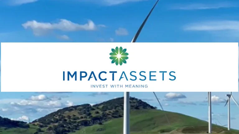 Green rolling hills with wind mills against a blue cloudy sky