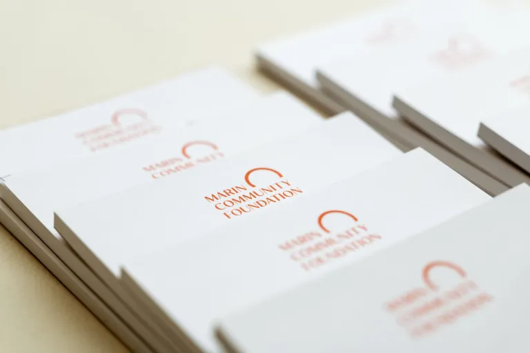 Stack of splayed notepads with the MCF logo at the top