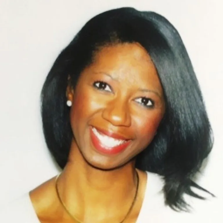 Image of Nichole Walker head and shoulders, smiling, wearing a white shirt and chain