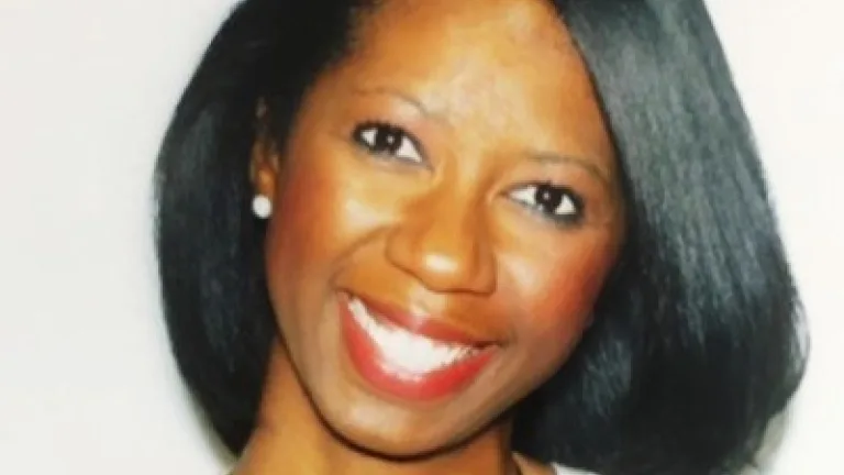 Image of Nichole Walker head and shoulders, smiling, wearing a white shirt and chain