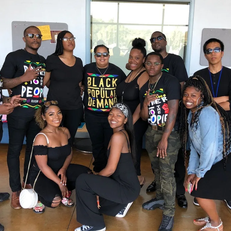 A group of young, black adolescents pose happily for a photo.