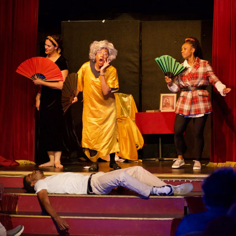 Griot theater members performing on stage.