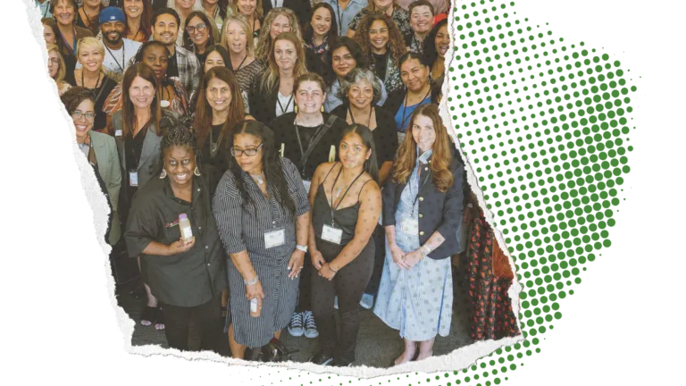 Group of diverse people smiling for a photo at a gathering, with a torn paper edge effect.