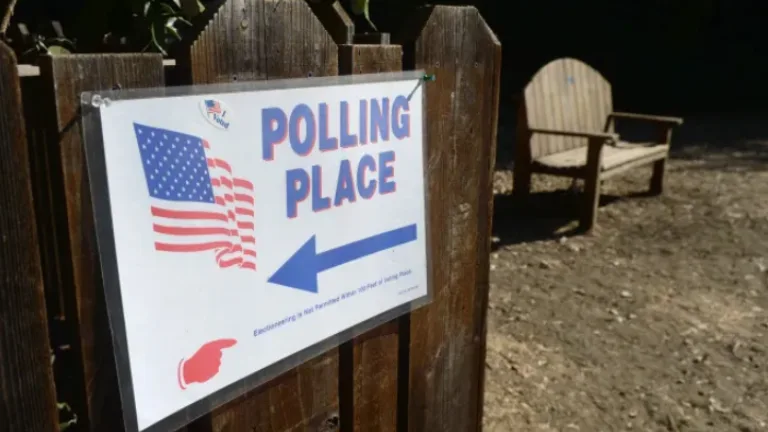 Open fence gate with Polling Place sign attached