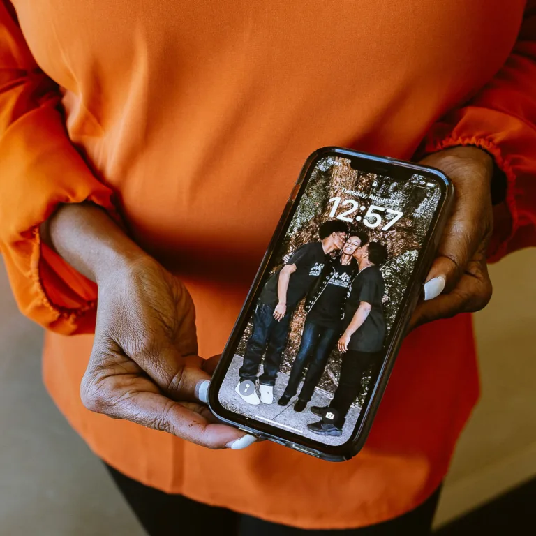 LaCrecia Williams holding phone with picture of family