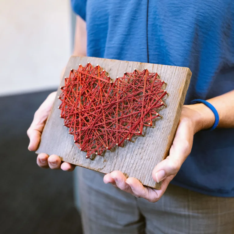 Patti D’Angelo Juachon holding heart string artwork