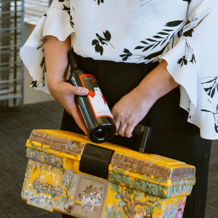 Jennifer Anderson holding wine and toolbox