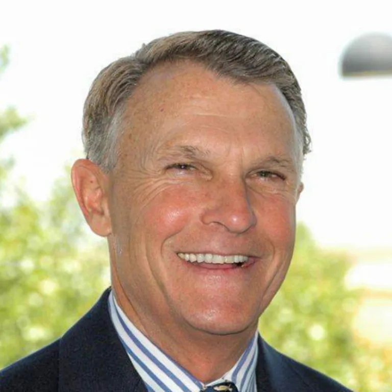 Headshot of Robert Reynolds wearing a blue and white dress shirt and dark grey jacket