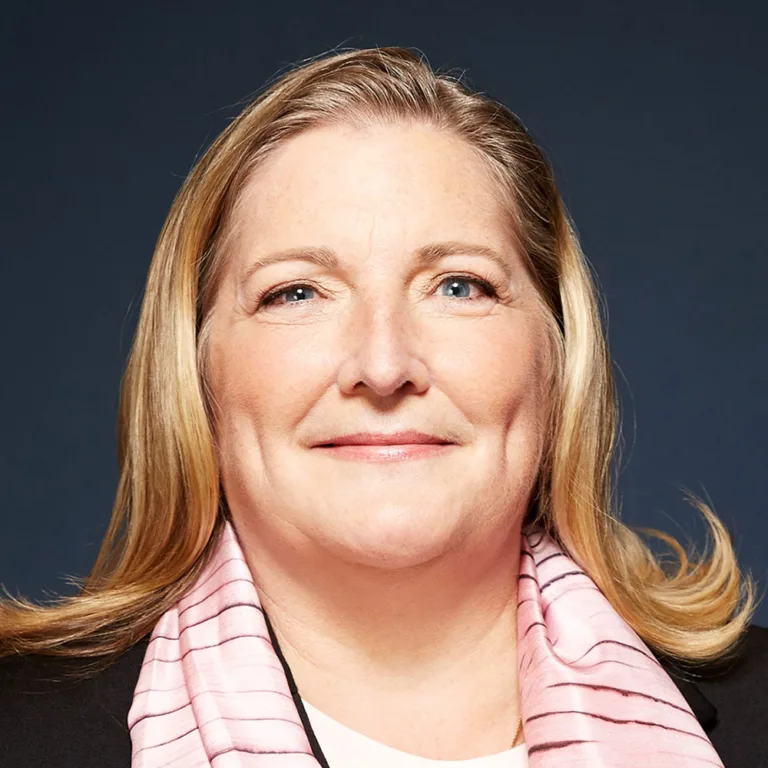 Headshot of Debra Wetherby wearing a dark brown jacket and pink and brown scarf