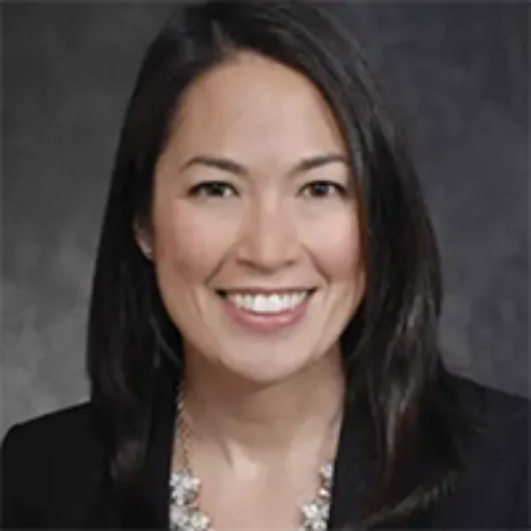 Headshot of Julia Matsudaira wearing a dark jacket and printed blouse