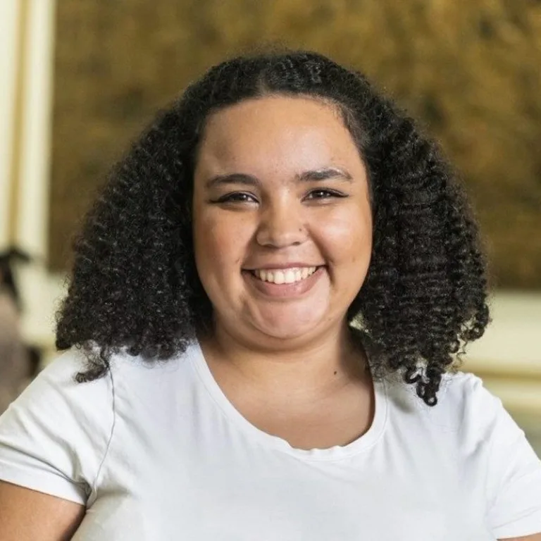 Serena Selgado head and shoulders image, smiling at camera wearing a white tee shirt