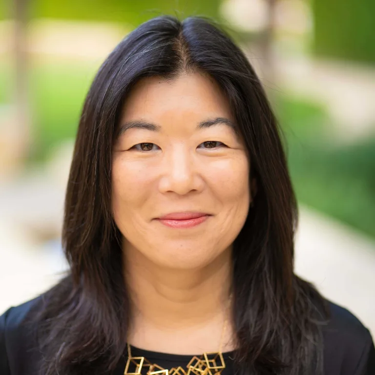 Aileen Lee, MCF Board of Directors Headshot of Aileen Lee, smiling at camera, wearing a black top and gold necklace