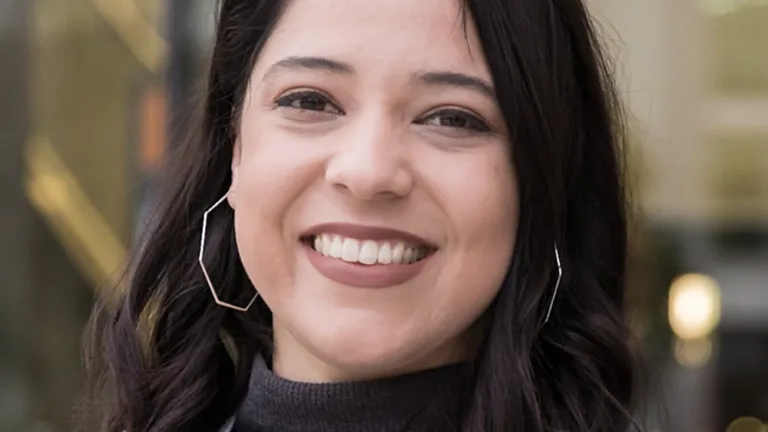 Headshot of Stephanie Martinez wearing a dark grey mock turtleneck and light grey sweater