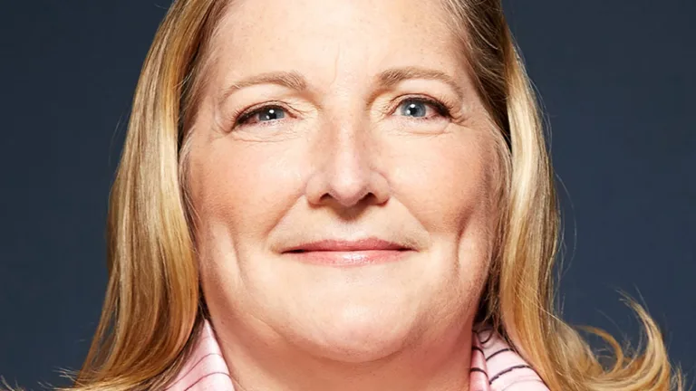 Headshot of Debra Wetherby wearing a dark brown jacket and pink and brown scarf
