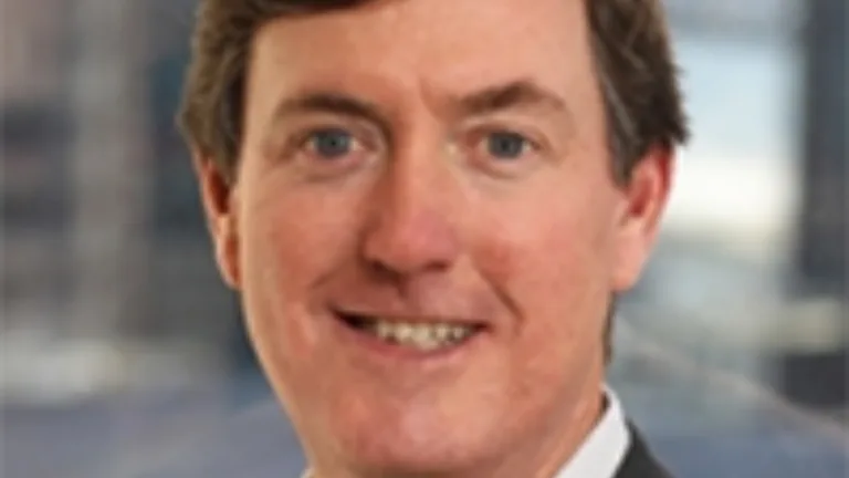 Headshot of Frank Cassidy wearing a white dress shirt and brown jacket