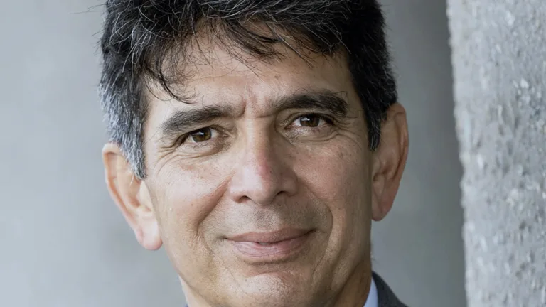 Headshot of Ralph Gonzalez wearing a white dress shirt and grey tie and jacket
