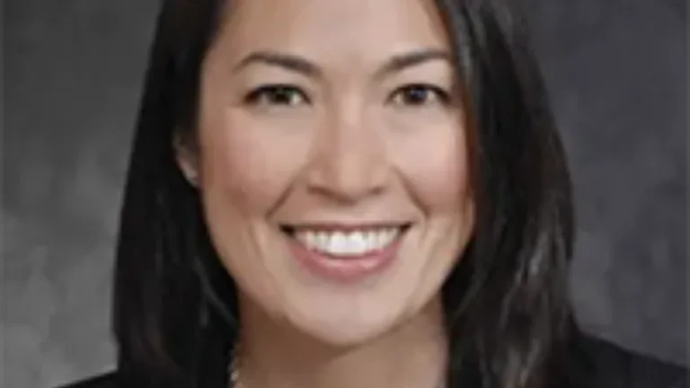 Headshot of Julia Matsudaira wearing a dark jacket and printed blouse