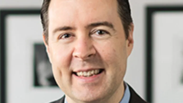 Headshot of Patrick McCabe wearing a light blue dress shirt, brown jacket, and brown tie
