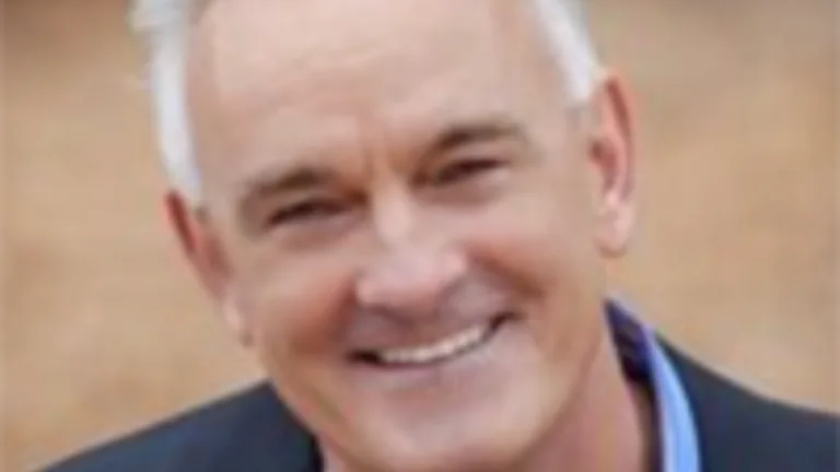 Headshot of Dave Schrader wearing a blue shit and dark blue jacket